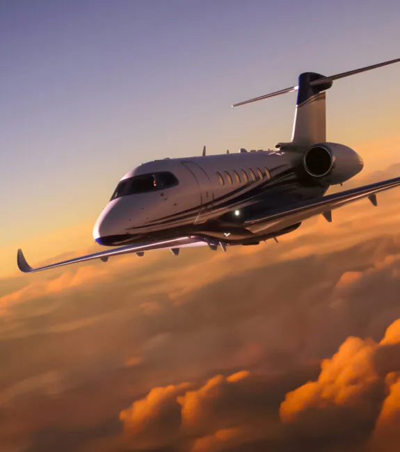 Private jet airborne above the clouds at sunset