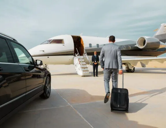 Business traveler approaching a private aircraft on the tarmac