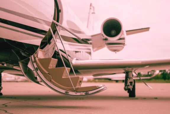 Private aircraft with open cabin door on airport tarmac